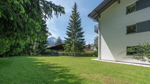 Un bâtiment moderne doté d’une pelouse bien entretenue et de grands arbres.