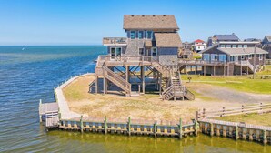 A coastal building with multiple decks and a staircase leading to the upper levels. - Soundfront Home w/ Private Boat Dock, Game Room, Windsports Access, & More! (Avon)