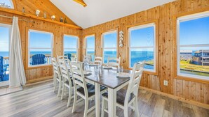A wooden-paneled room with a dining table and chairs, large windows with ocean views, and a wooden ceiling. - Soundfront Home w/ Private Boat Dock, Game Room, Windsports Access, & More! (Avon)