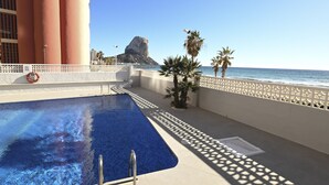 Uma piscina com vista para o mar e um conjunto de rochas ao fundo.