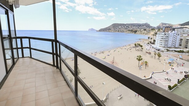 Uma varanda com vista para a praia e edifícios.