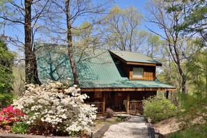A cabin with a green roof, surrounded by trees and flowering plants. - Mountain Views & Very Private! Free Putt Putt, Swimming Pool, Golf, Fishing, etc (Sevierville)