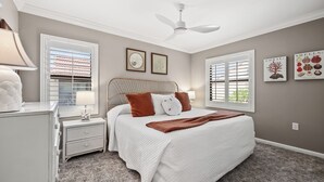 A bedroom with a bed, nightstands, a ceiling fan, and artwork on the walls. - Cozy Garden View 1 bed, 1 bath at Sanibel Moorings #912 (Sanibel)