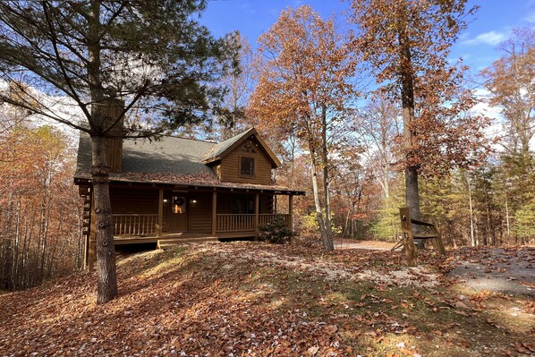 A cabin with a porch, surrounded by trees and fallen leaves. - Arcade Games, Pool Table, FREE access to Pool and Putt Putt, 5 miles to town (Sevierville)