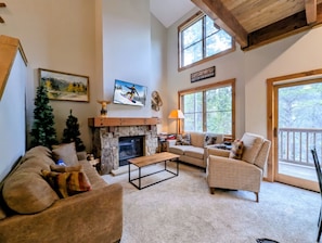 A cozy living room with a fireplace, a sofa, a coffee table, and a large window. - Shuttle to Lifts/Walk to Lakeside Village, Hot Tub (Keystone)