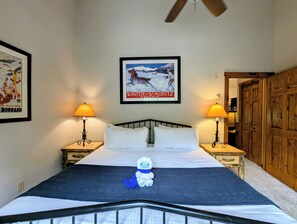 A bedroom with a bed, two bedside lamps, a framed picture on the wall, and a wooden wardrobe. - Shuttle to Lifts/Walk to Lakeside Village, Hot Tub (Keystone)