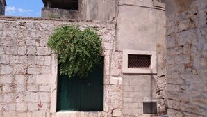 Un estrecho callejón con una puerta verde y una pequeña ventana.