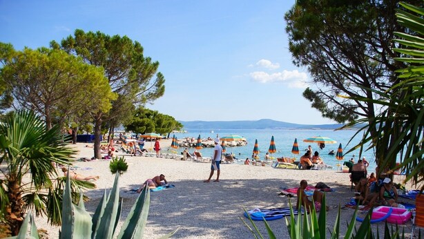 A beach with people sunbathing, umbrellas, and a clear view of the sea. - Apartment in Crikvenica with Seaview, Terrace, Air condition, WIFI (3492-6) (Crikvenica)