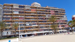 A multi-story hotel with balconies, a beachside location, and palm trees. - A47 CALPEMAR C 5º 19 (Calpe)