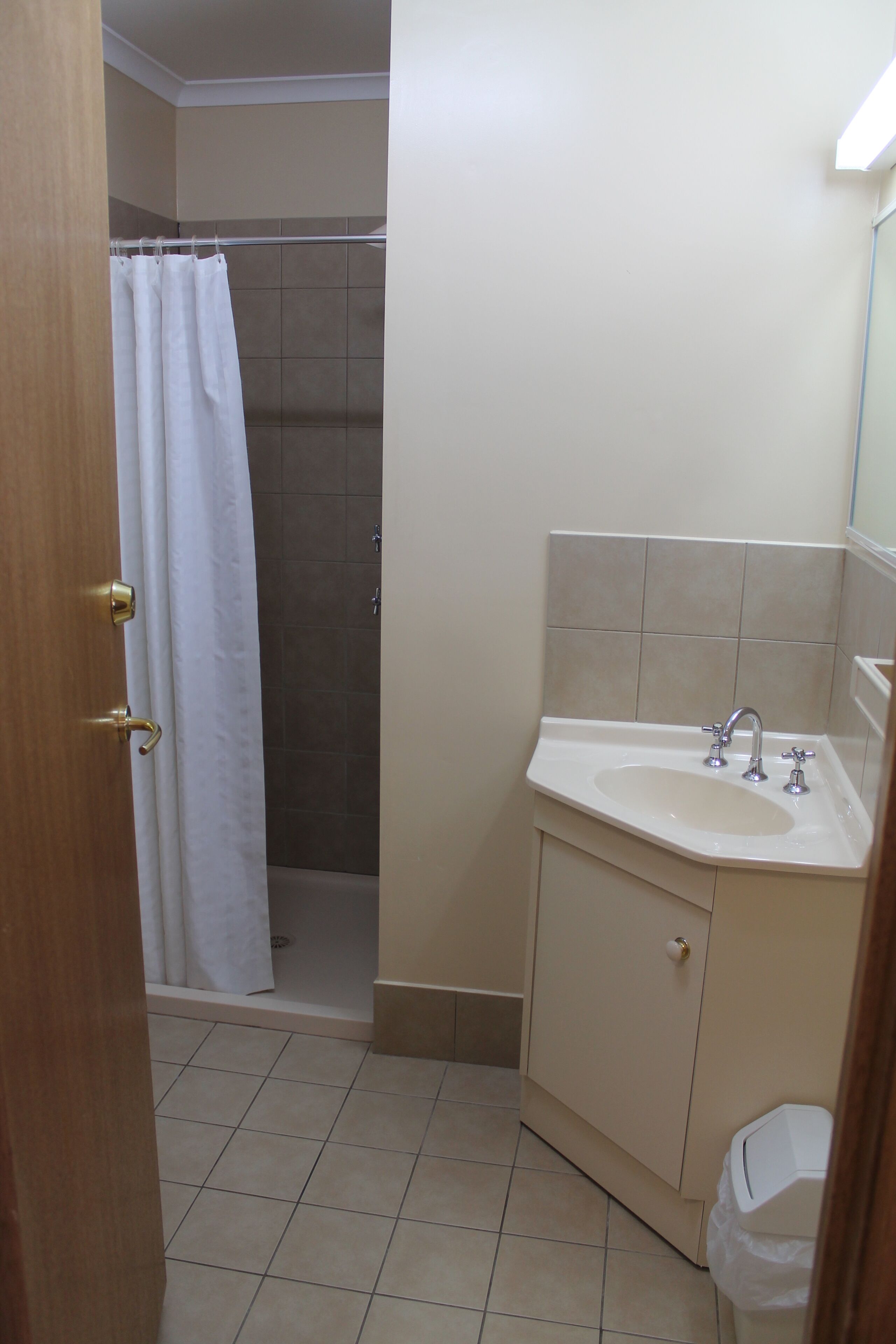 Une salle de bain avec une douche, un lavabo et des toilettes.