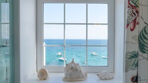 A window with a view of the sea and boats, a white wall, and a decorative curtain. - Casa Lola, Sea Front Apartment in Playa Blanca (Playa Blanca)