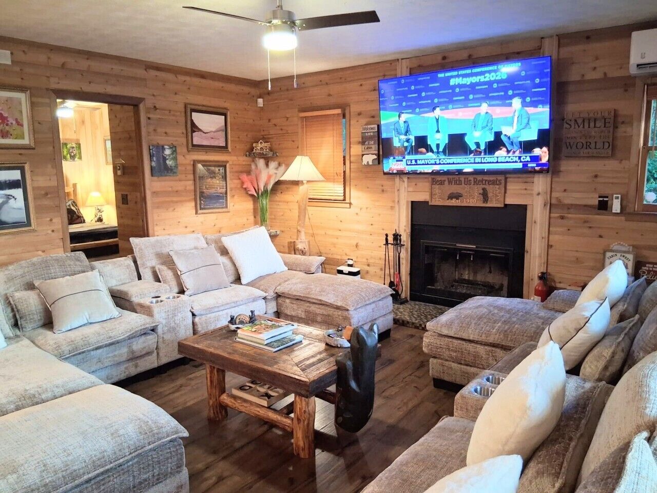 Ein gemütliches Wohnzimmer mit Kamin, Fernseher und einer Holzwand.