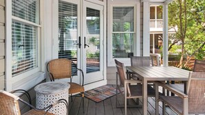 A covered porch with a 'WELCOME' sign, wicker chairs, a table, and a ceiling fan. - Ground Floor, Screened Porch, Free Beach Chair Service, Large Pool (Miramar Beach)