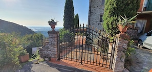 Enter a serene oasis surrounded by lush greenery and a stone building with a window and balcony.