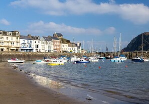 Traditional coastal buildings line the shoreline, offering a serene beachside setting.
