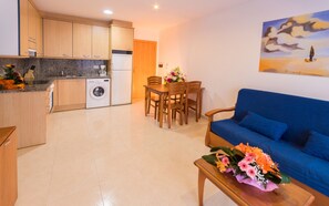 A compact living space with a kitchen, dining area, and a sofa.