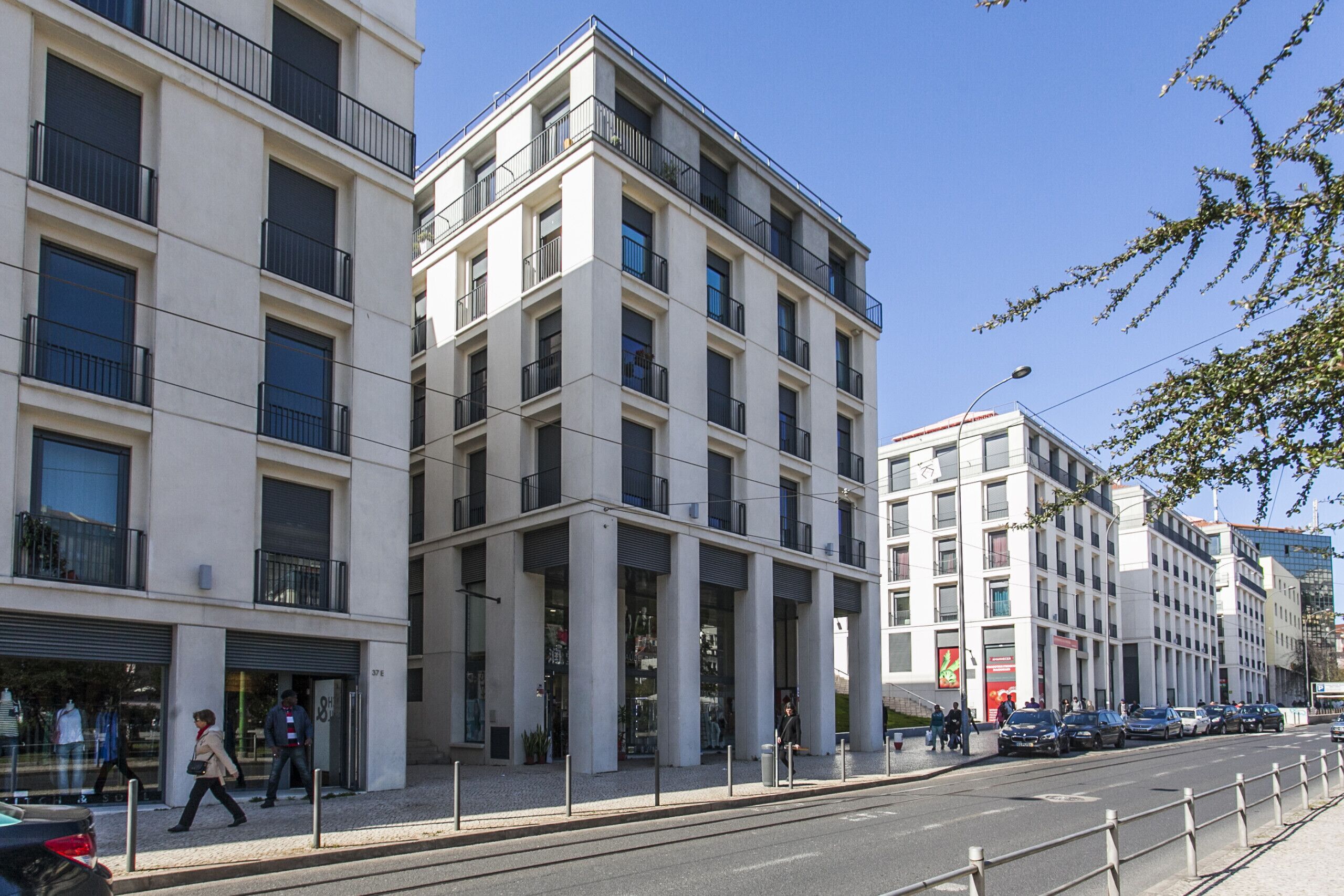 Ein modernes Gebäude mit mehreren Stockwerken, großen Fenstern und Balkonen.