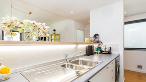 Una cucina moderna con lavello in acciaio inossidabile, forno integrato e lavastoviglie.