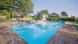 A rectangular swimming pool with a clear blue water surface, surrounded by a brick deck. There are lounge chairs and a pergola with a roof. - Villa in San Leonardo with 4 bedrooms sleeps 8 (San Leonardo)
