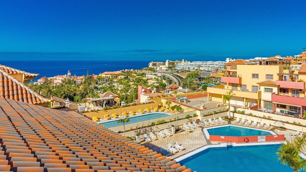 A resort with a swimming pool, sun loungers, and a view of the ocean. - TERRAZAS DEL DUQUE II COSTA ADEJE (Costa Adeje)