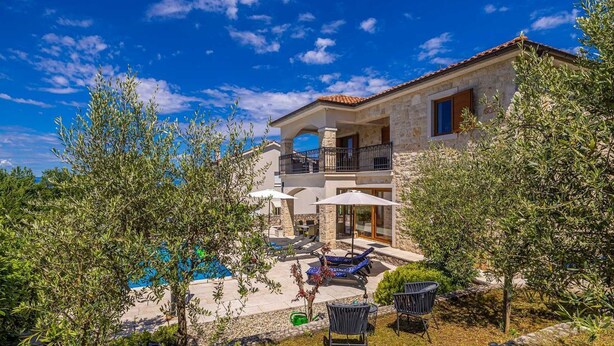 A two-story stone house with a pool, outdoor seating, and a balcony. - Holiday house OBZOVA with private heated pool (Ljutići)