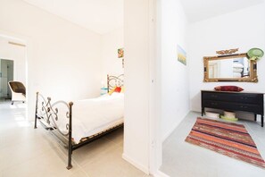 A bedroom with a bed, a dresser, a mirror, and a rug.