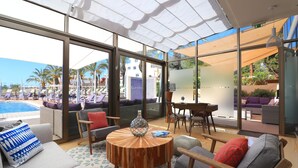 A modern lounge area with a pool view, comfortable seating, and a round wooden table. - Parque nº 11 - Comfortable Duplex Apartment (Ferragudo)