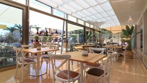 A spacious indoor area with multiple tables and chairs, large windows, and a ceiling with a translucent canopy. - Parque nº 11 - Comfortable Duplex Apartment (Ferragudo)