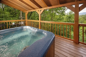 A hot tub on a wooden deck with a view of a forest. - Private, Hot Tub, Mtn View, FREE Amenities, 5 miles from Pigeon Forge!! (Sevierville)