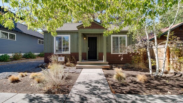 A residential house with a front porch, a small garden with dry plants, and a clear sky. - Aspen House- Sweet, Modern Downtown Cottage, 100+mbps Wifi, A/C, Walk Everywhere (Bend)