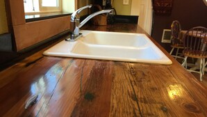 A kitchen with a white sink, wooden countertop, and a window in the background. - Aspen House- Sweet, Modern Downtown Cottage, 100+mbps Wifi, A/C, Walk Everywhere (Bend)