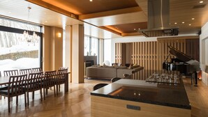 Un amplio salón con un piano, una gran mesa de comedor y una zona de estar acogedora.