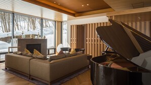 Una sala de estar moderna con un sofá seccional, un piano y una chimenea.