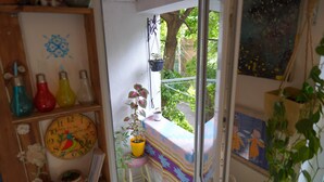 A narrow balcony with a small stool, a potted plant, and a colorful cloth draped over the railing. - Helen and David's apartment,, Bird's nest" (Didube-Chugureti)