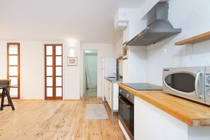 Una cocina moderna con microondas, horno y campana extractora de acero inoxidable.