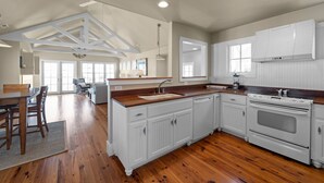 A spacious kitchen with white cabinetry, a wooden countertop, and a large island. - Neuse Village #5 - Quaint, tranquil cottage with pool & amazing views (Arapahoe)