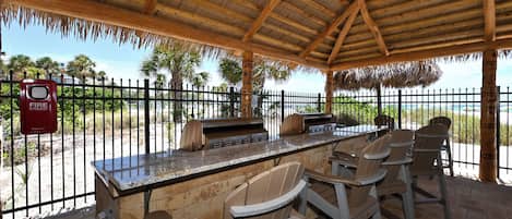 An outdoor barbecue area with a grill, seating, and a fire extinguisher.