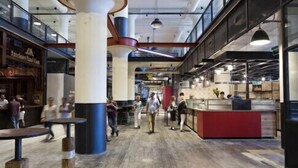 An indoor public space with high ceilings, exposed ductwork, and a mix of seating areas and counters. - Ponce City Market Studio · Heart of Atlanta · BeltLine (Atlanta)