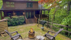 A cabin with a fire pit in the backyard, surrounded by outdoor furniture. - Private Cabin, Hot Tub, Pool Table, Walking Distance to Fishing Pond (Sevierville)
