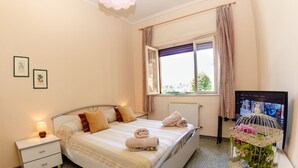 Une chambre à coucher avec un lit, une table de chevet et une cage à oiseaux décorative agrémentée de fleurs.