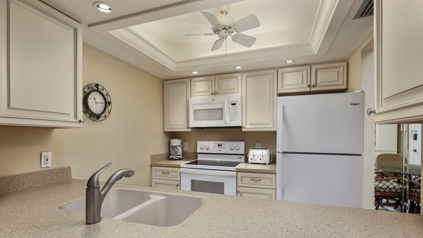 A kitchen with a sink, stove, microwave, and refrigerator. - Partial Beach View 2 bed, 2 bath at Sanibel Moorings #742 (Sanibel)