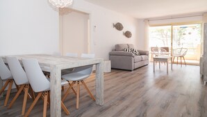 Een moderne woonkamer met een eettafel, bank en stoelen.