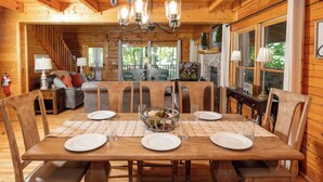 Une table à manger en bois, dressée pour quatre personnes, avec des sets de table, des assiettes et des verres.