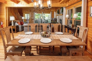 A wooden dining table set for four with placemats, plates, and glasses.