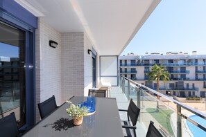 A balcony with a table, chairs, and a potted plant. - Spacious family apartment with sea views and pool · UHC MAR AUGUSTA 083 (Cambrils)