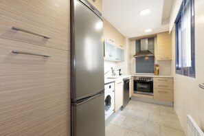 Een moderne keuken met roestvrijstalen apparatuur, houten keukenkastjes en een inbouwoven.