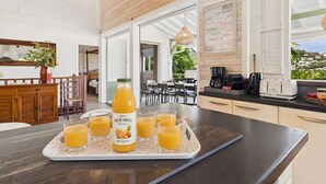 Eine moderne Küche mit einem Frühstücksbrett, Orangensaft, einer Kaffeemaschine und einem Toaster.