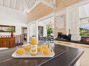 Eine moderne Küche mit einem Frühstücksbrett, Orangensaft, einer Kaffeemaschine und einem Toaster.