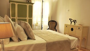 A bedroom with a bed, a bedside table, a lamp, a chair, and a cabinet. - Refurbished apartment with air conditioning in the center of Setúbal (Setúbal)