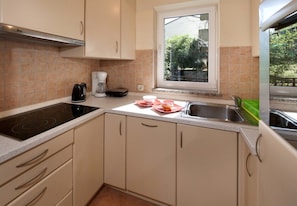 Une cuisine avec une fenêtre, une cuisinière et un évier.